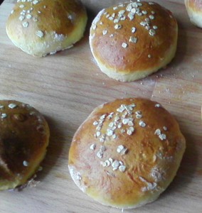 Die Hamburgerbrötchen sind mit Eigelb bestrichen und mit Haferflocken bestäubt. Anstatt Öl habe ich hier Butter verwendet. Ansonsten bleibt der Teig wie im Grundrezept beschrieben.