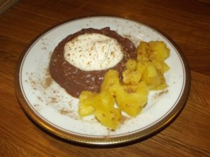 Schokoladenpudding mit Sahne und karamellisierter Ananas. 