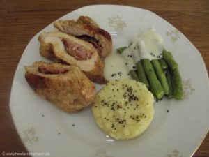 Cordon bleu mit Speck-Mett-Salbei-Füllung, Kartoffelstampf, grüne Bohnen, Béchamelsauce und als Finish schwarzes Hawaii Salz.