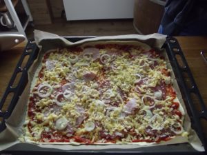 Pizza mit Schinken, Salami und Zwiebeln